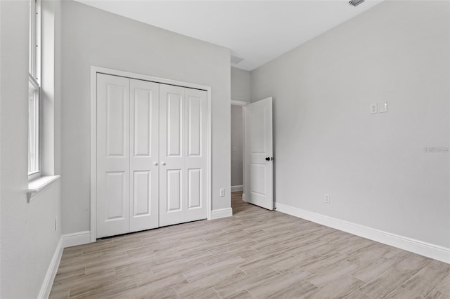 unfurnished bedroom featuring light hardwood / wood-style floors and a closet