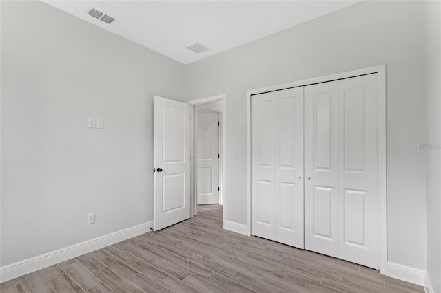 unfurnished bedroom with a closet and light wood-type flooring