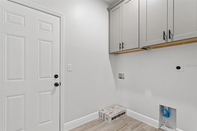 laundry room featuring hookup for an electric dryer, washer hookup, light wood-type flooring, and cabinets