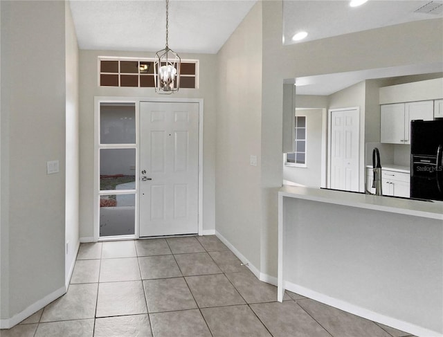 entryway featuring light tile patterned flooring and a chandelier