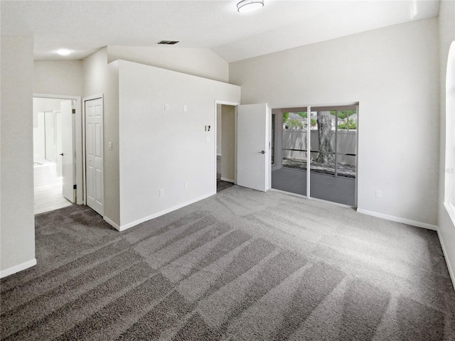 unfurnished room with high vaulted ceiling and dark carpet