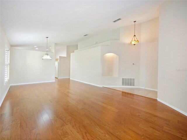 unfurnished room with a chandelier and wood-type flooring