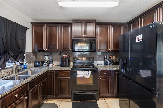 kitchen featuring light tile patterned flooring, dark brown cabinets, sink, and black appliances