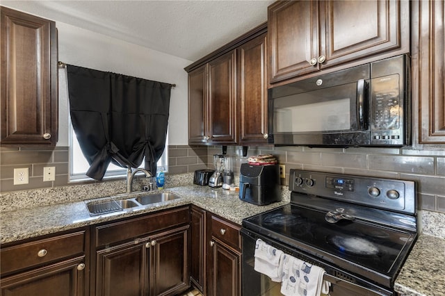 kitchen with sink, decorative backsplash, dark brown cabinets, and black appliances