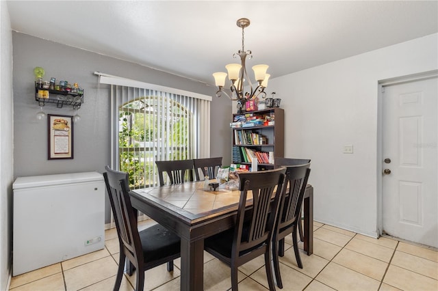 dining space featuring light tile patterned flooring and a notable chandelier