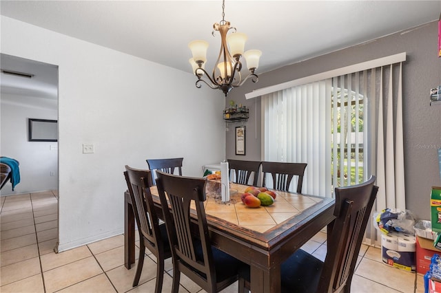 tiled dining room featuring a notable chandelier