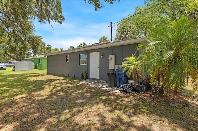 rear view of property featuring a lawn