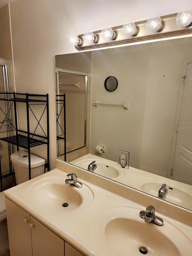 bathroom featuring toilet, tile patterned floors, and dual bowl vanity