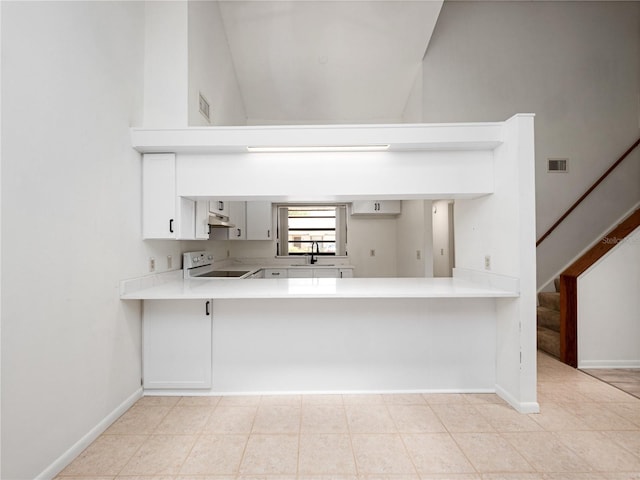 225 Terrace Hill Blvd Unit 1C, Debary, FL 32713 - kitchen with electric range, light countertops, a peninsula, baseboards, and a high ceiling
