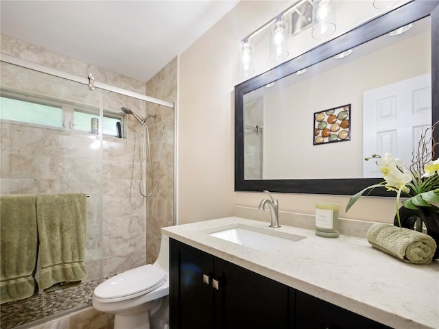 full bathroom featuring vanity, a shower stall, and toilet