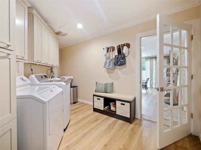 laundry room with visible vents, baseboards, washing machine and dryer, light wood-style floors, and cabinet space