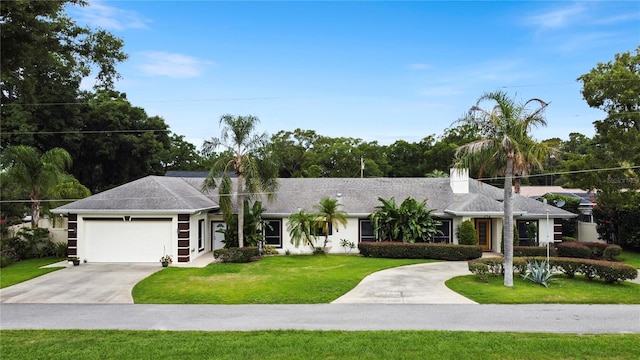 view of front of home featuring a garage, concrete driveway, and a front lawn