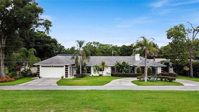 view of front of property featuring a garage, concrete driveway, and a front lawn