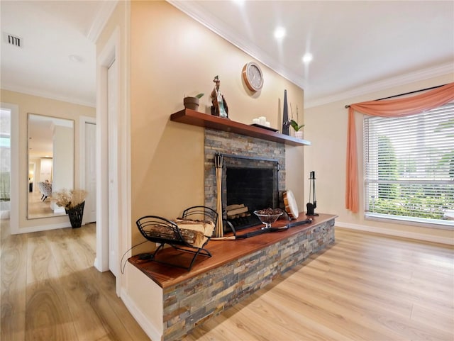 living room featuring visible vents, a fireplace, crown molding, and wood finished floors