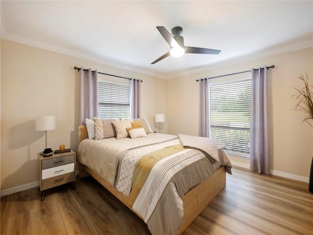 bedroom featuring crown molding, wood finished floors, and baseboards