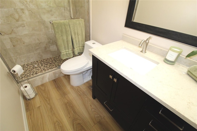 full bathroom with toilet, a shower stall, wood finished floors, and vanity