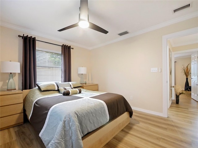 bedroom featuring crown molding, light wood-style floors, and visible vents