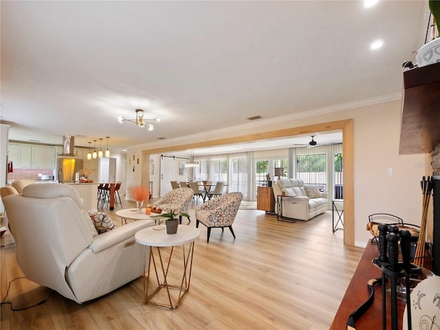 living area with light wood-style floors, visible vents, and ornamental molding