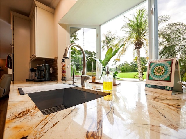 interior space featuring a sink and light stone countertops