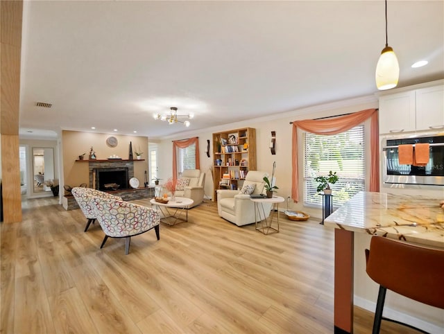 living room featuring a fireplace, light wood-style flooring, and crown molding