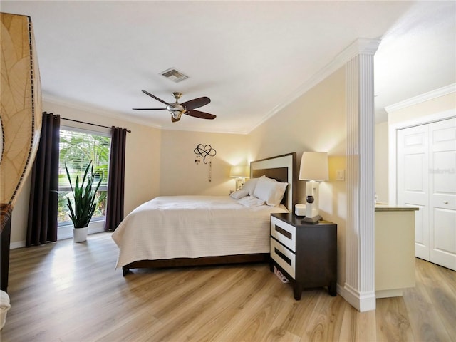 bedroom featuring light wood-style floors, visible vents, and ornamental molding