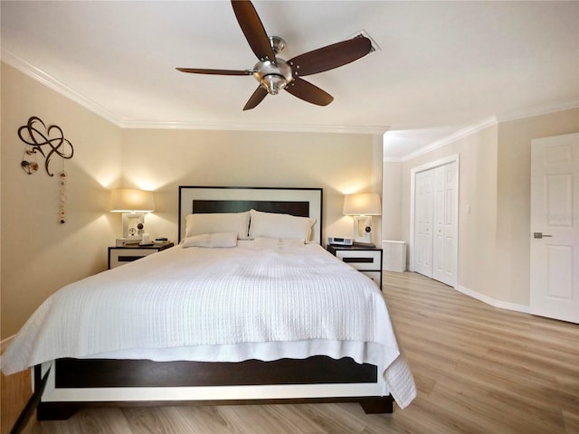 bedroom with a closet, baseboards, wood finished floors, and crown molding