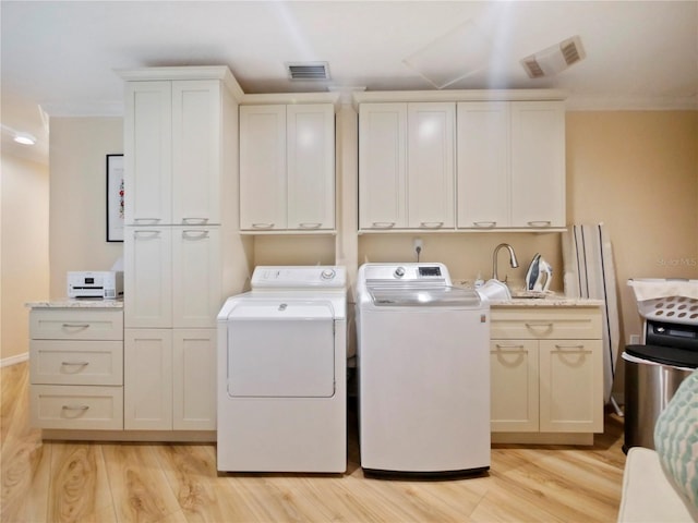 laundry room featuring laundry area, light wood-type flooring, visible vents, and washing machine and clothes dryer