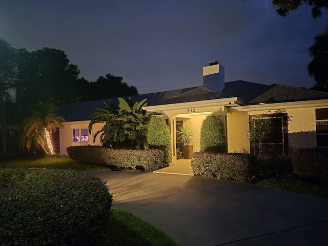 single story home featuring stucco siding and a chimney