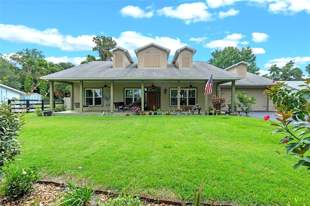 back of property with ceiling fan, a yard, and covered porch