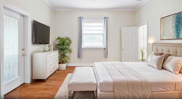 bedroom featuring light wood finished floors, baseboards, and ornamental molding