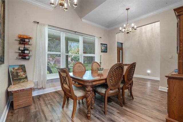 dining space featuring baseboards, a notable chandelier, wood finished floors, and crown molding