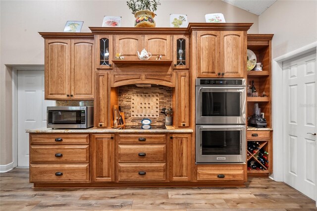 kitchen with light wood finished floors, tasteful backsplash, vaulted ceiling, appliances with stainless steel finishes, and open shelves