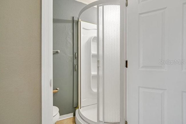 bathroom featuring toilet and walk in shower