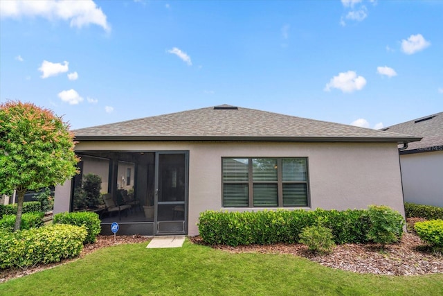 rear view of property with a sunroom and a lawn