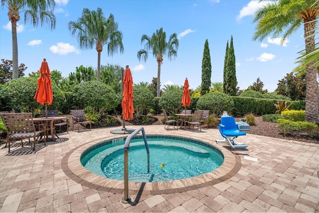 view of swimming pool featuring an in ground hot tub and a patio