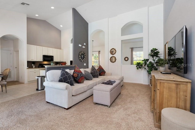 carpeted living room featuring high vaulted ceiling