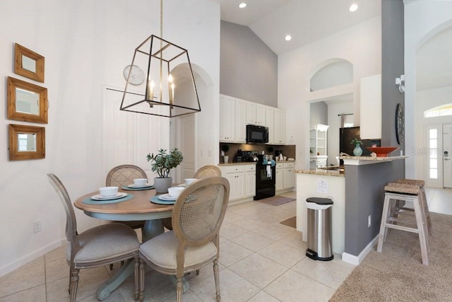 tiled dining room with high vaulted ceiling and a notable chandelier