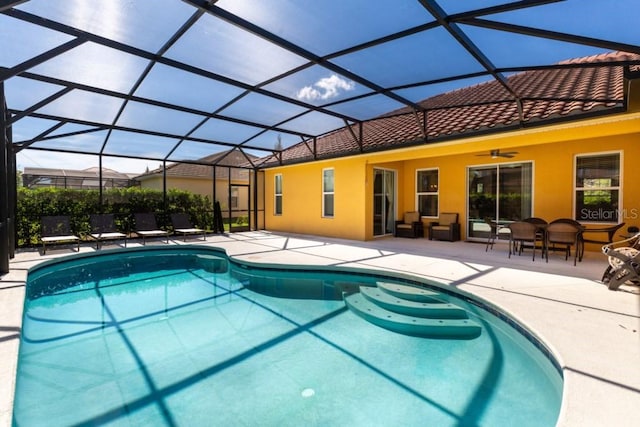 view of pool with ceiling fan, a lanai, and a patio area