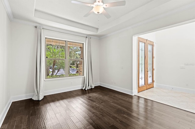 empty room with ceiling fan, light hardwood / wood-style flooring, a raised ceiling, and ornamental molding