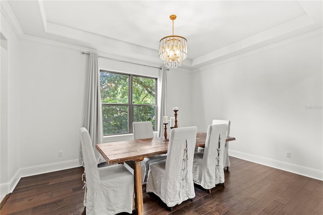 dining space featuring an inviting chandelier, a tray ceiling, crown molding, and dark hardwood / wood-style flooring