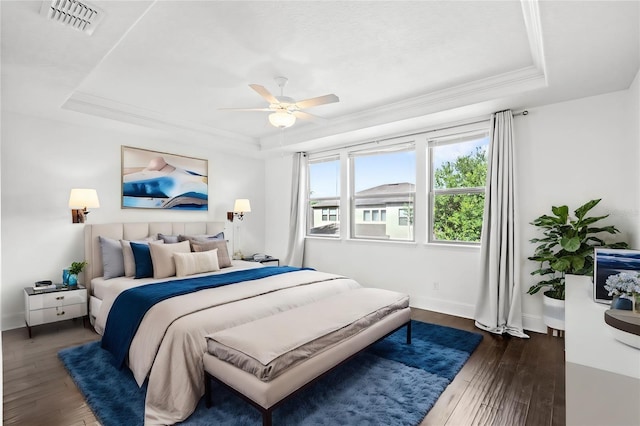 bedroom featuring ornamental molding, ceiling fan, a raised ceiling, and dark wood-type flooring