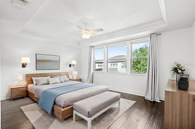 bedroom with ceiling fan, ornamental molding, a tray ceiling, and dark hardwood / wood-style flooring