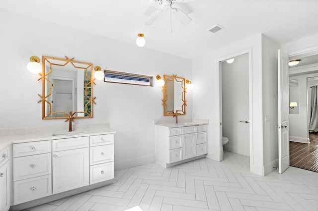 bathroom featuring ceiling fan, vanity, and toilet