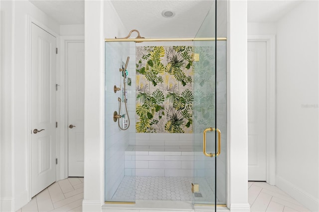 bathroom with a textured ceiling, a shower with door, and tile patterned floors