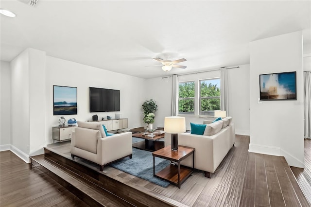 living room with dark hardwood / wood-style flooring and ceiling fan