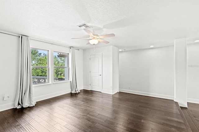 empty room with ceiling fan, a textured ceiling, and dark wood-type flooring