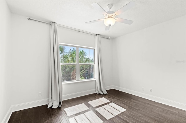 spare room with a textured ceiling, dark wood-type flooring, and ceiling fan