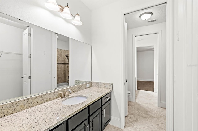 full bathroom with vanity, toilet, tiled shower / bath combo, a textured ceiling, and tile patterned flooring