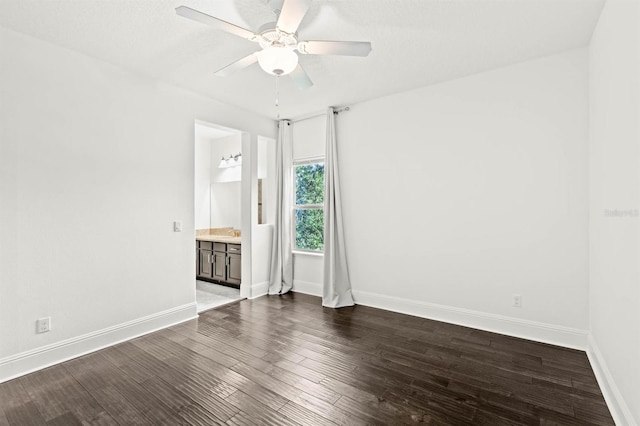 unfurnished bedroom with ensuite bath, ceiling fan, and dark hardwood / wood-style flooring