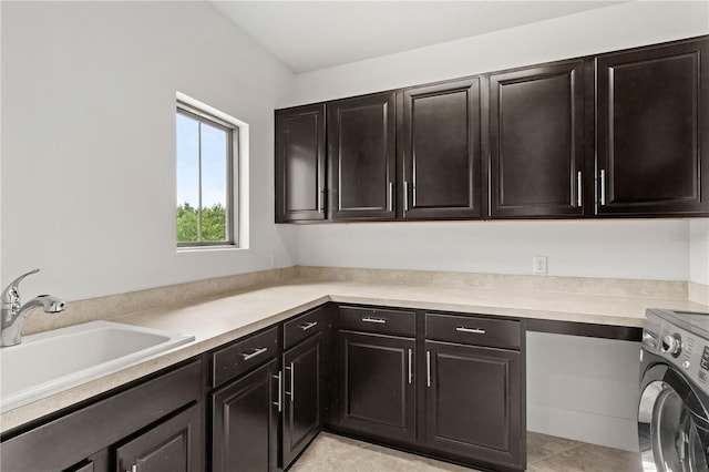 washroom with light tile patterned flooring, cabinets, sink, and washer / dryer